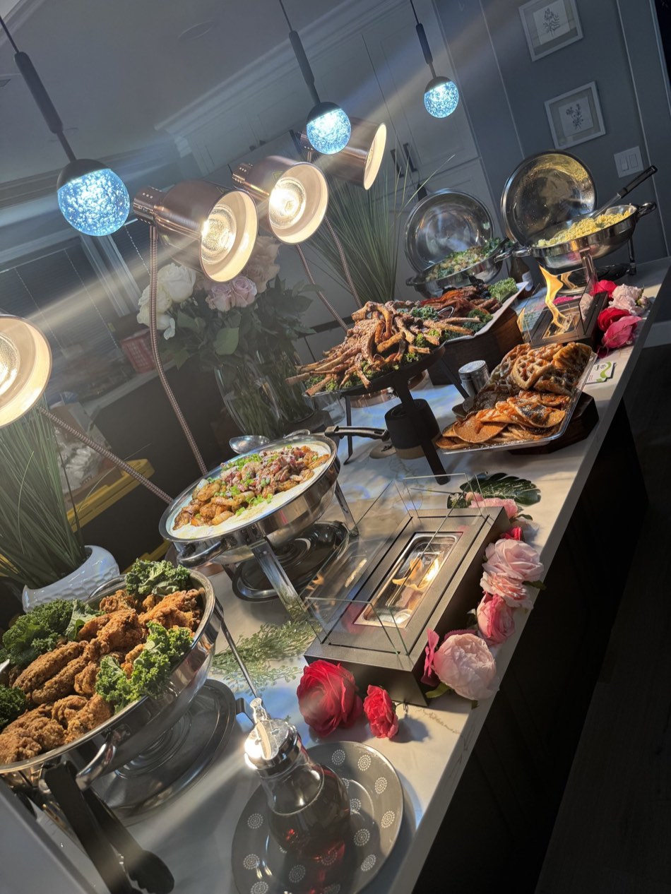 Styled brunch buffet with lamb chops and waffles under heat lamps