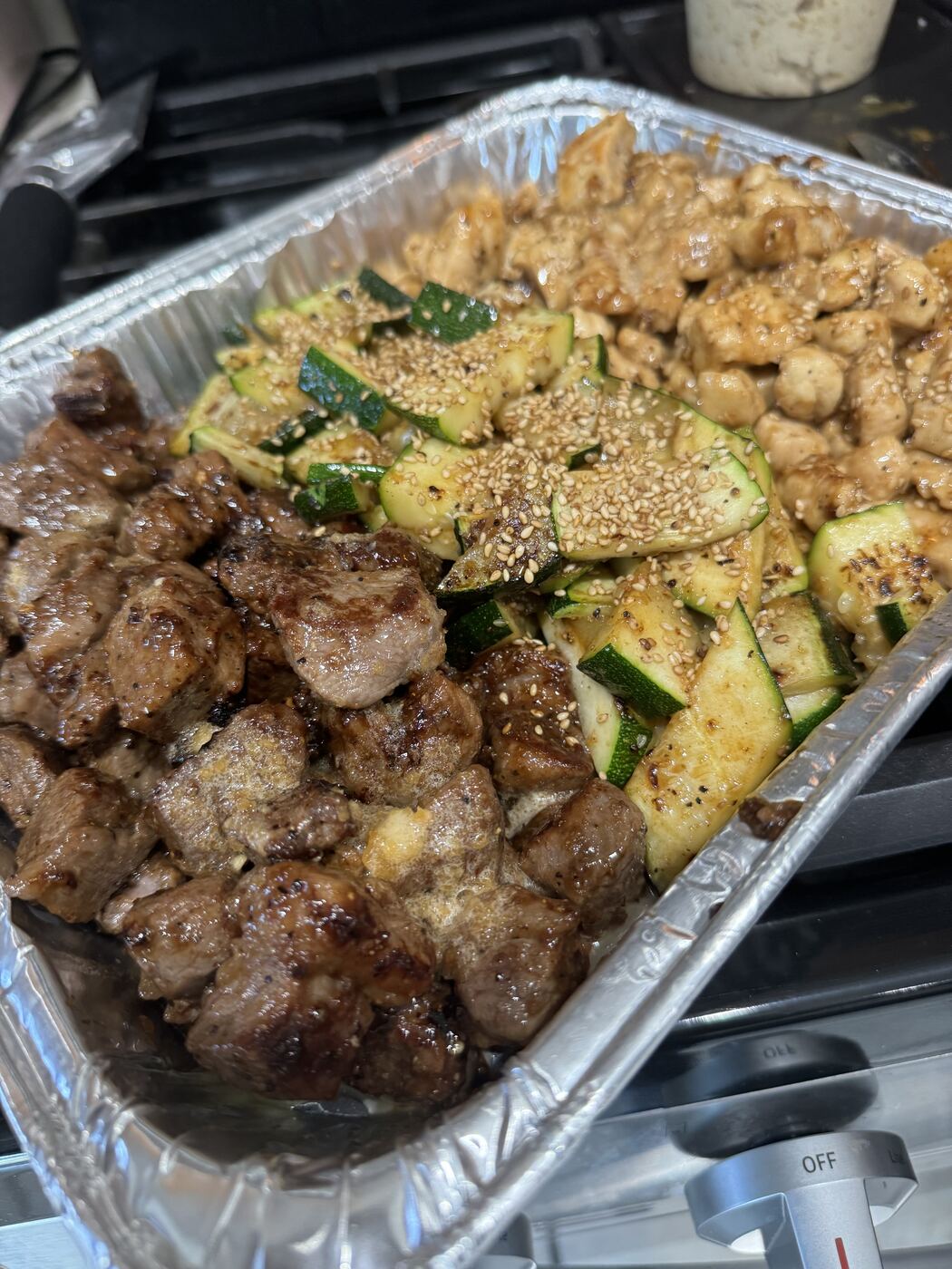 Hibachi catering tray of steak, chicken and zucchini, up close