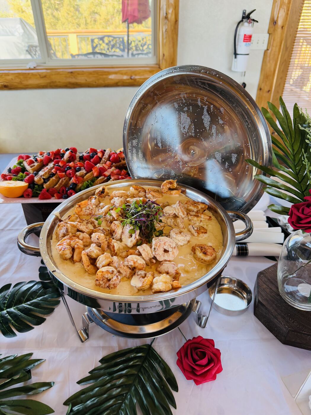 Chafing dish of shrimp and grits on a styled spread